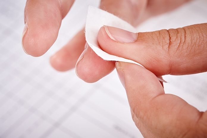 Fingers using sterile swab on skin before blood test