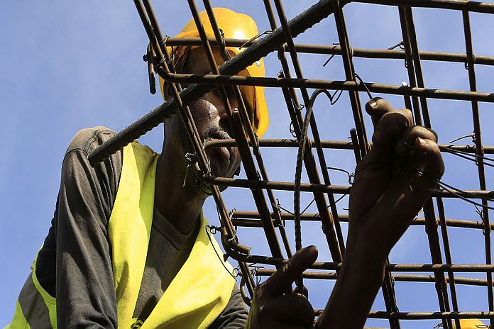 Construction workers work on an overpass bridge, a section of the Mombasa-Nairobi standard gauge railway (SGR), in Emali