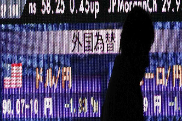 A man walks past a board showing nikkei stock price index  and foreign currency exchange rates outside of a brokerage in Tokyo